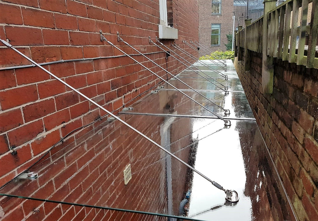 Bespoke stainless steel and glass walkway canopy running the length of a side passage alley in Sheffield