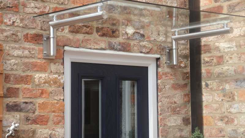 Stainless steel and glass door canopy over a front door