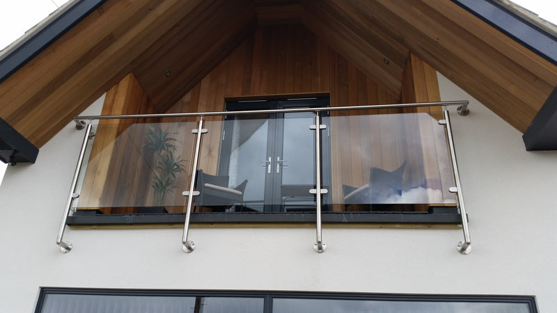 Stainless steel and glass Juliet balcony fitted to French doors on a brick house