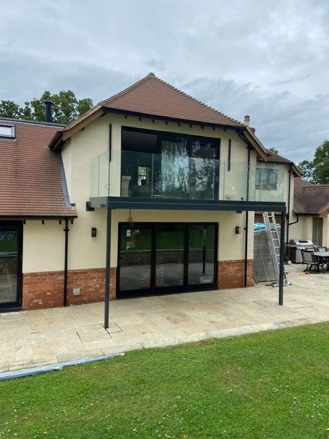 Large frameless glass walk-out balcony across a set of french doors