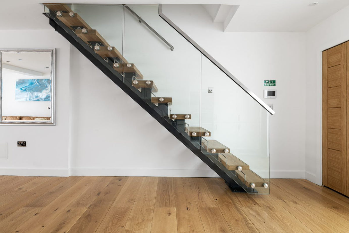 Steel spine staircase with oak treads and frameless glass balustrade