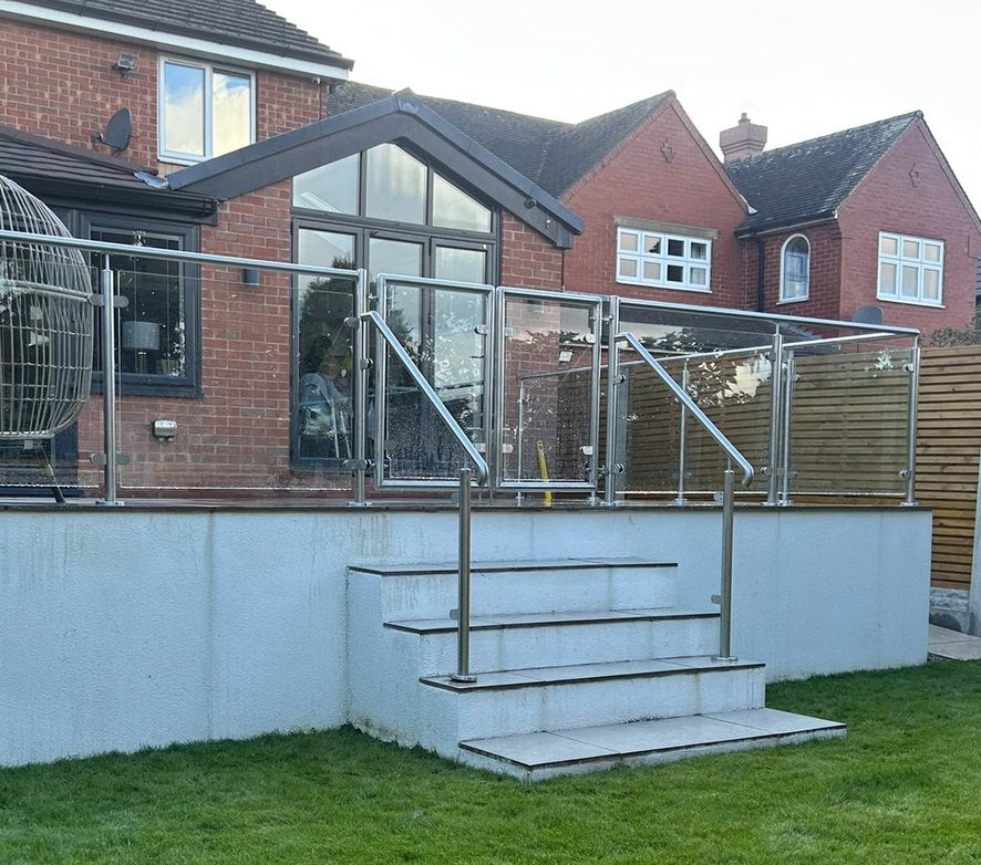 Pair of framed glass gates closed across the head of the steps on a raised patio in Rotherham