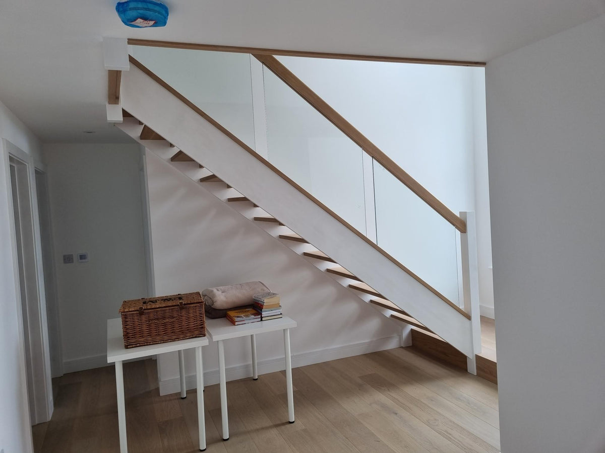 Open riser oak staircase with raking glass panels and a square glass panel to the landing