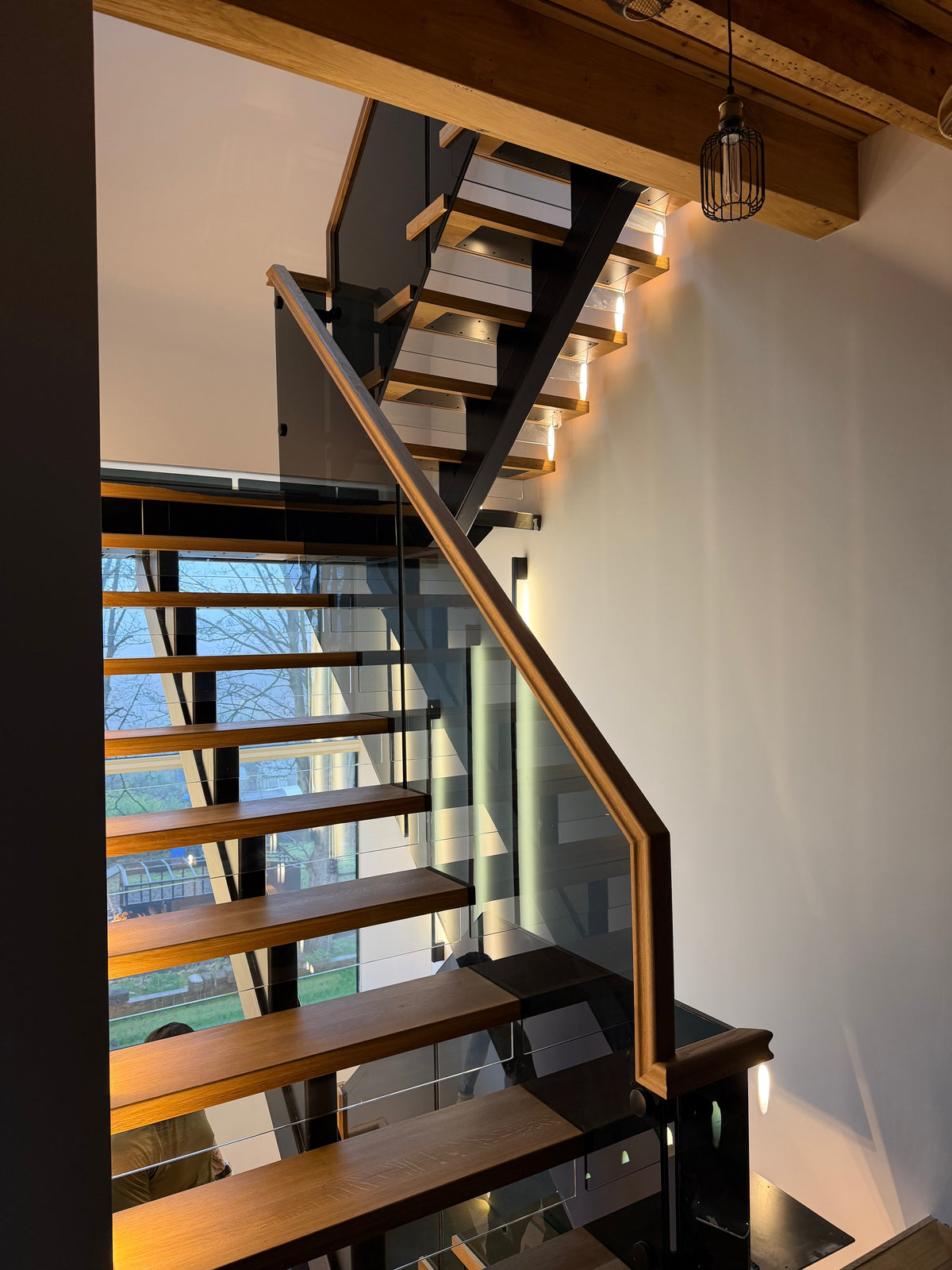 Steel spine staircase with oak treads, glass balustrade and integrated lighting
