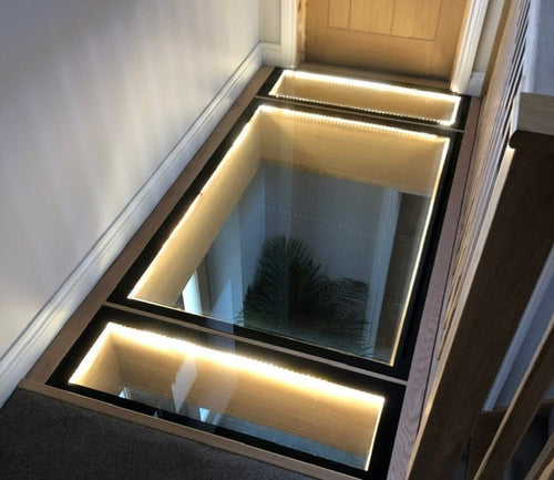 25.5mm walk-on glass floor panel in a steel frame with LED lighting to the reveal