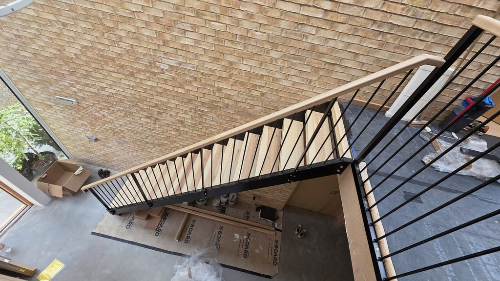 Steel staircase from above showing the pressed steel tread trays that close the open risers