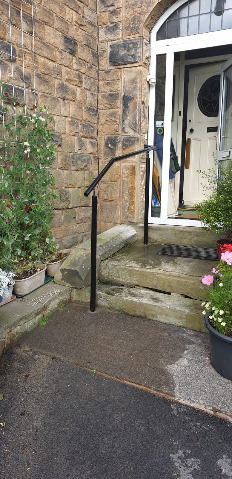 Powder coated steel handrail on posts to a path