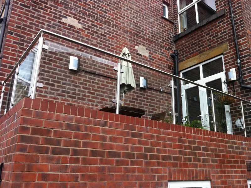 Stainless steel clamps fixed along a posted balustrade run
