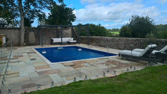 Frameless glass pool barrier standing on floor spigots with no posts or top rail
