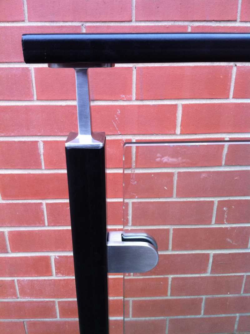 Glass clamps holding toughened infill panels on an external balcony balustrade