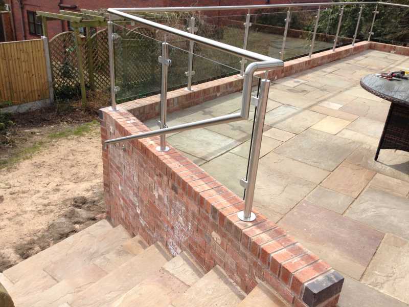 Wall mounted handrail running alongside a staircase on stainless steel brackets