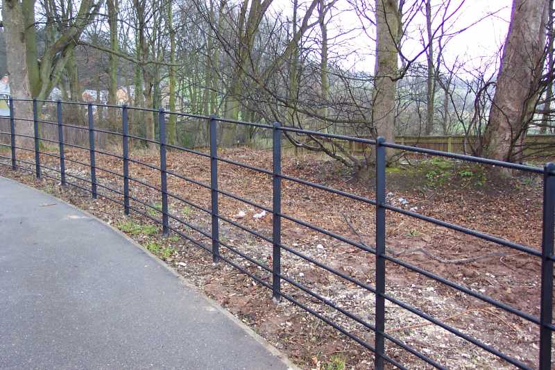 Steel estate rail fencing with horizontal bars through flat bar posts