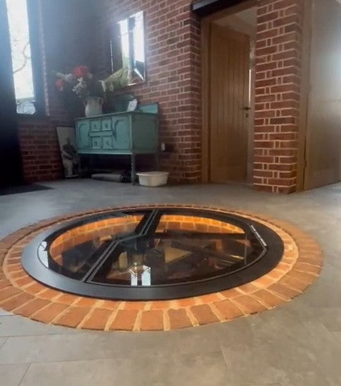 Automated circular glass wine cellar door opening on its actuator