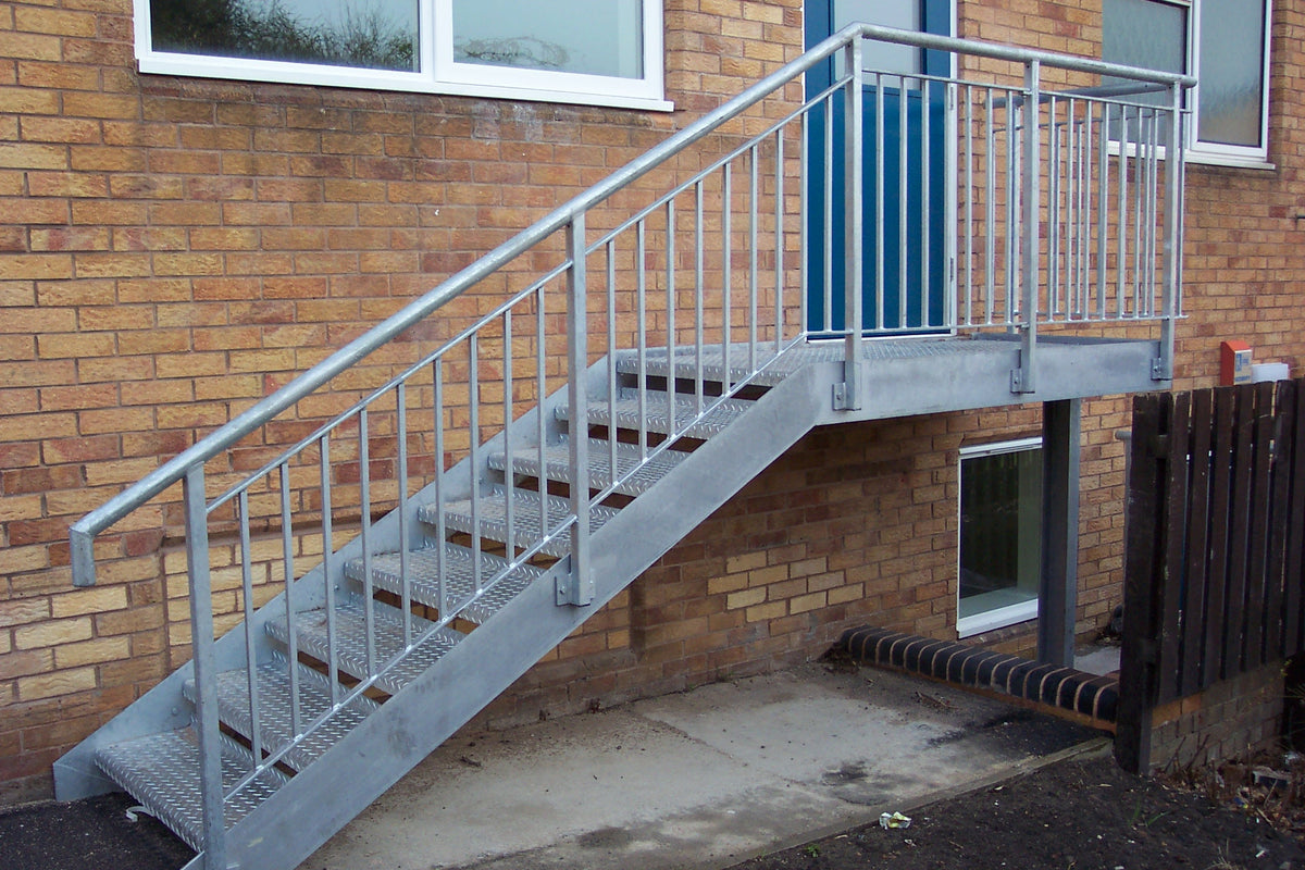 Galvanised steel access staircase with bar infill handrails to a first floor door