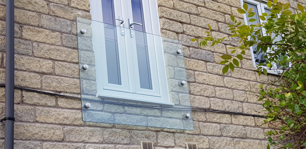 Frameless glass Juliet balcony with side-fixed stainless steel button fixings