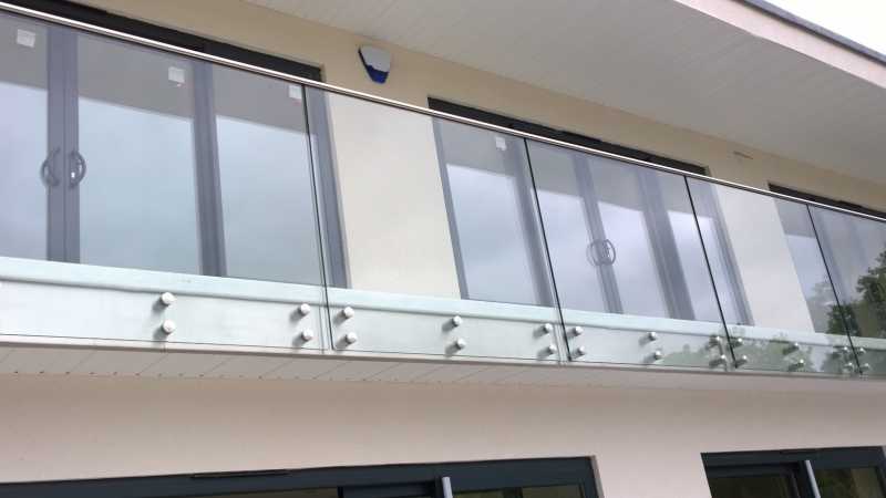 Face fixed frameless balustrade to a balcony, showing the stainless bolts
