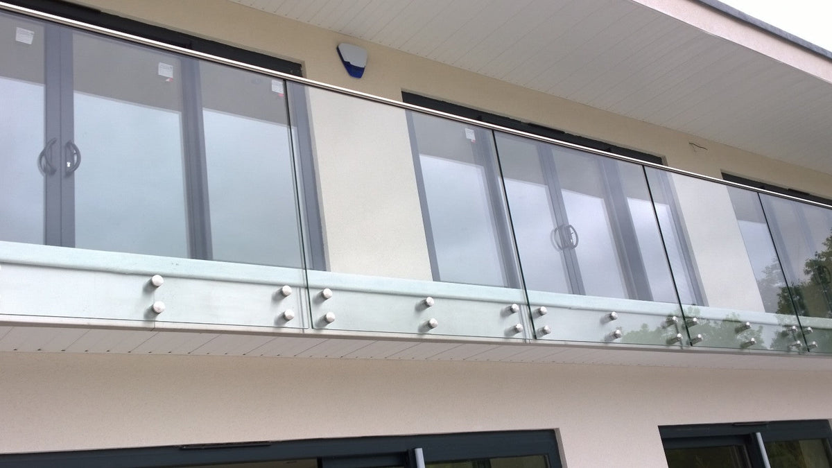 Long run of face fixed frameless laminated glass balustrade with a stainless top rail