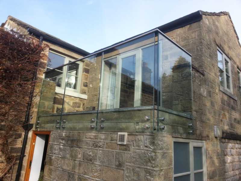 Frameless balcony balustrade system with a slotted stainless steel handrail
