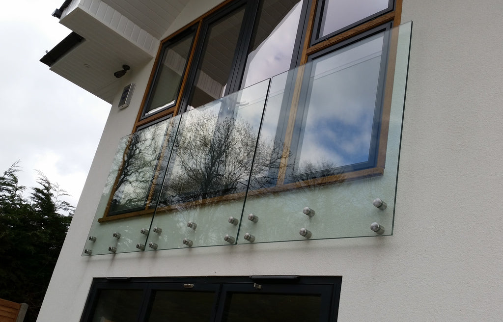 Face fixed laminated glass balcony panels on stainless steel discs with no handrail