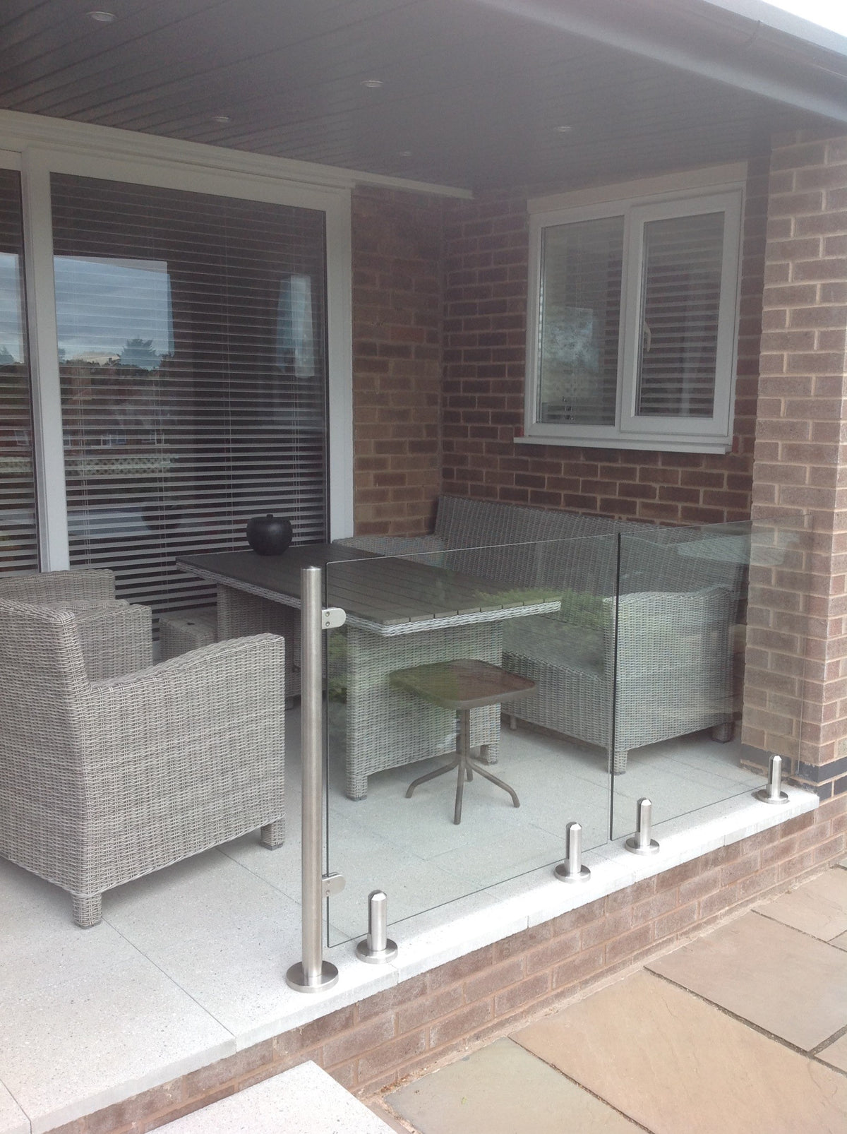 Brushed stainless floor spigot with a bolt fixing that passes through the glass