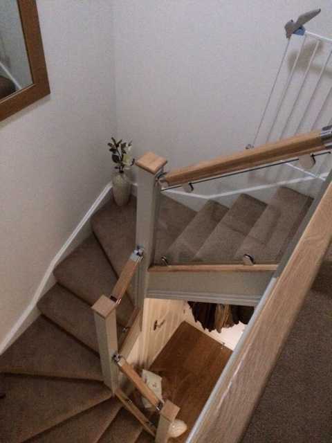Glass balustrade to a staircase with polished clamps along the string