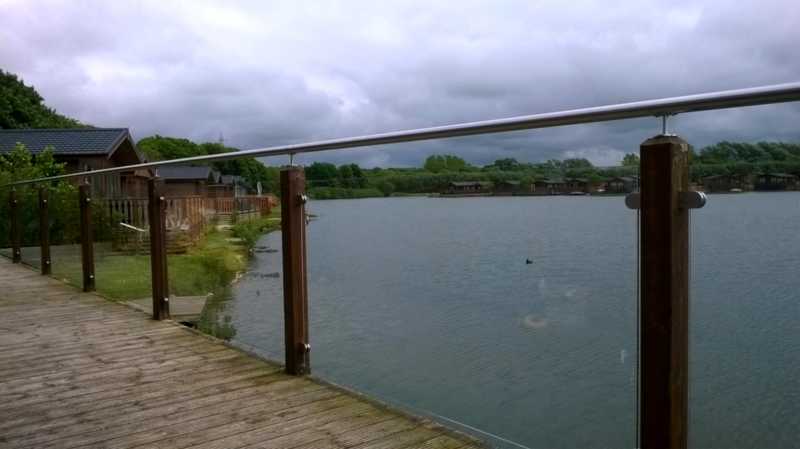 Glass decking balustrade with a stainless tubular handrail