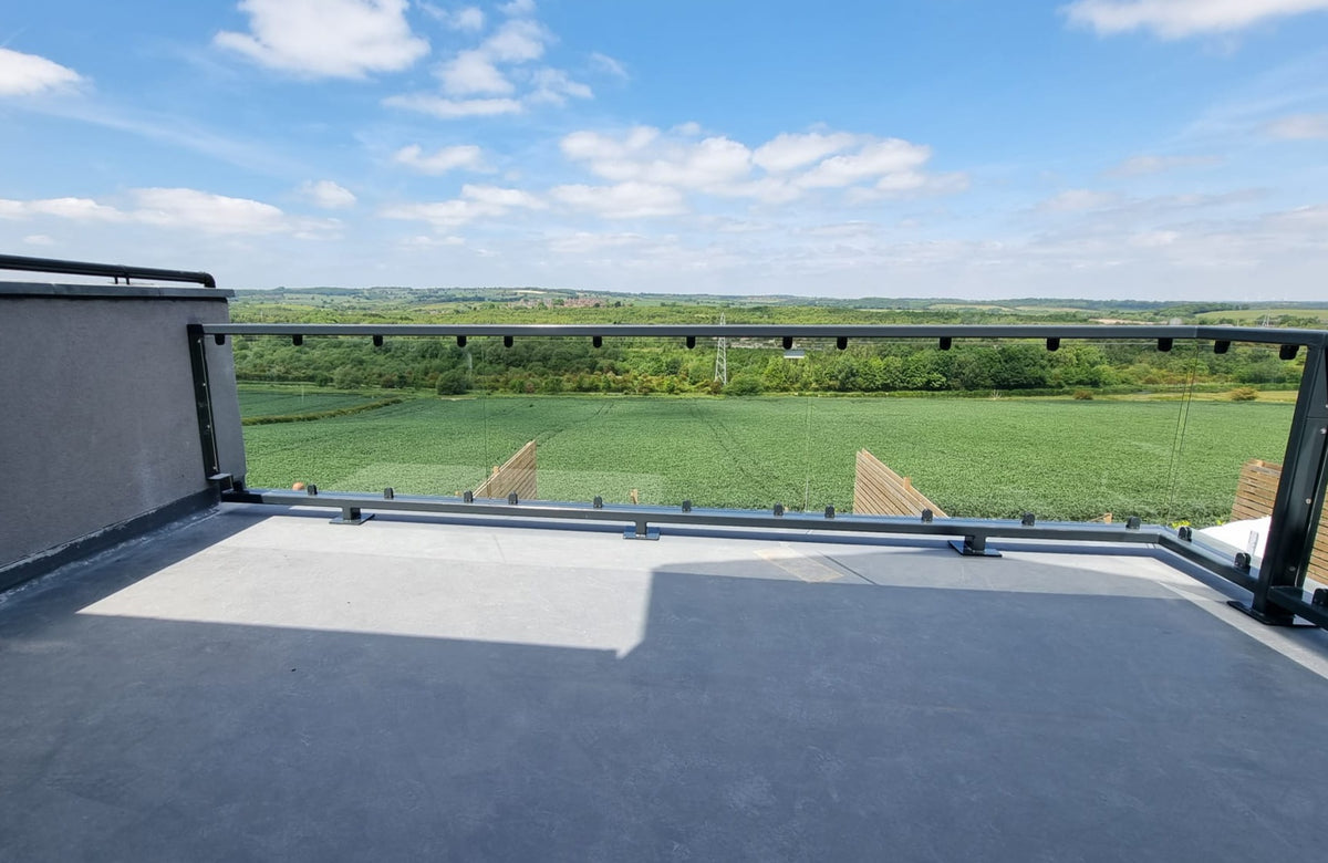 Flat roof glass balustrade with the waterproof covering left unpunctured