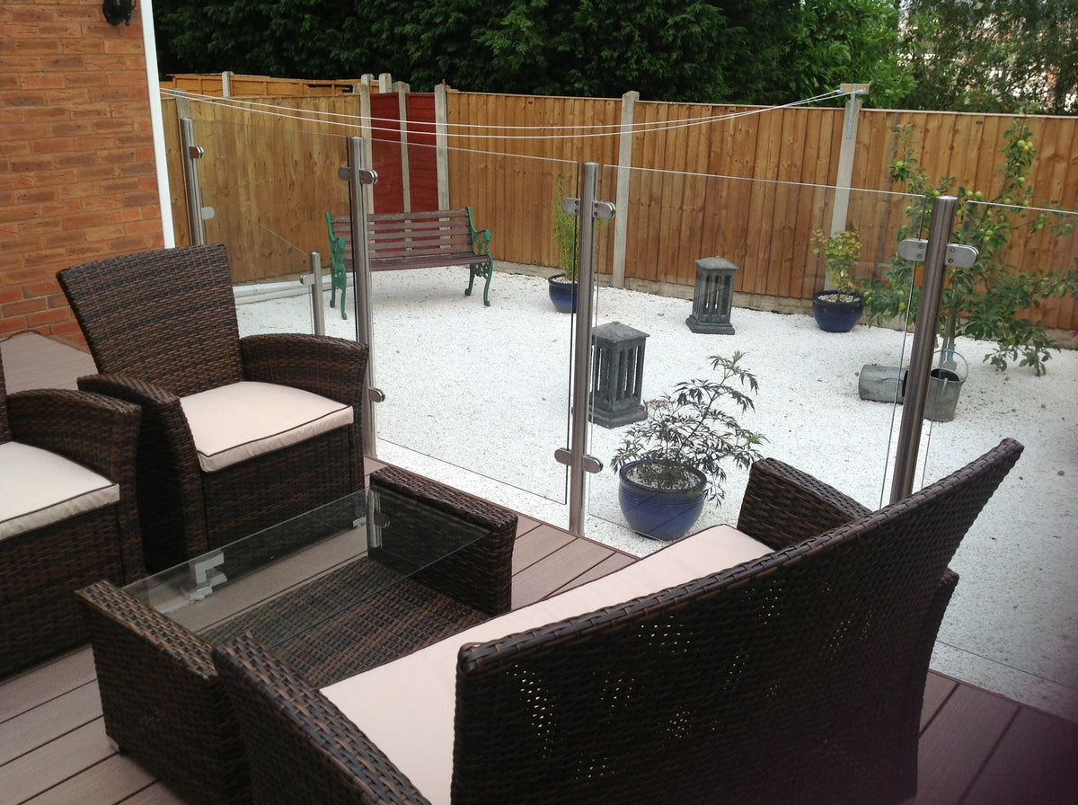 Laminated glass panels on brushed stainless posts enclosing a decked seating area