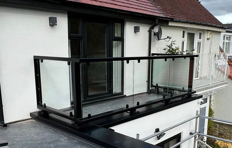 Glass balustrade carried on a structural handrail off a parapet wall
