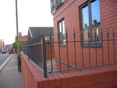 Steel dwarf railing panels on base plates fixed to a wall coping
