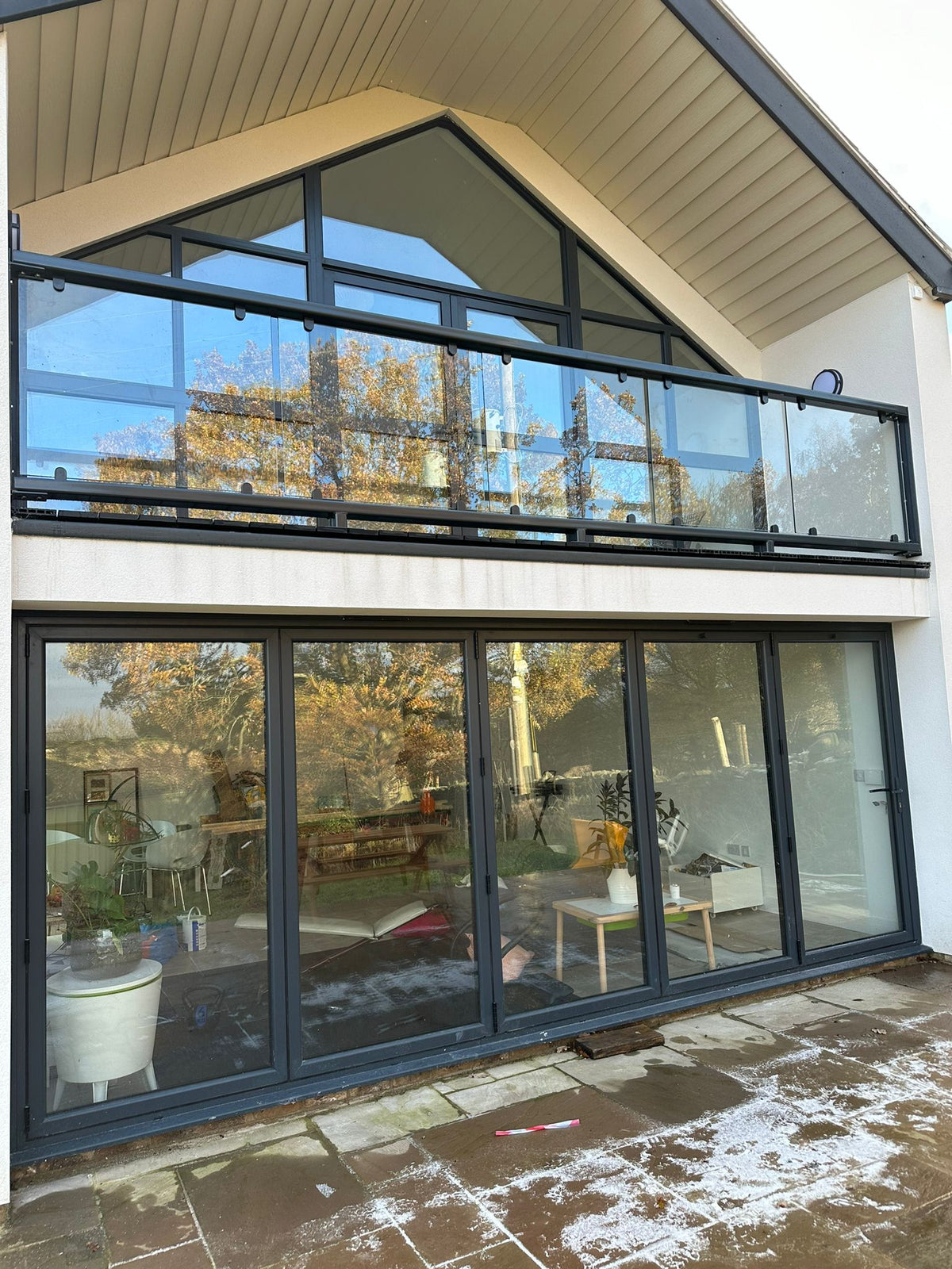 Anthracite grey powder coated glass balcony balustrade off a parapet wall