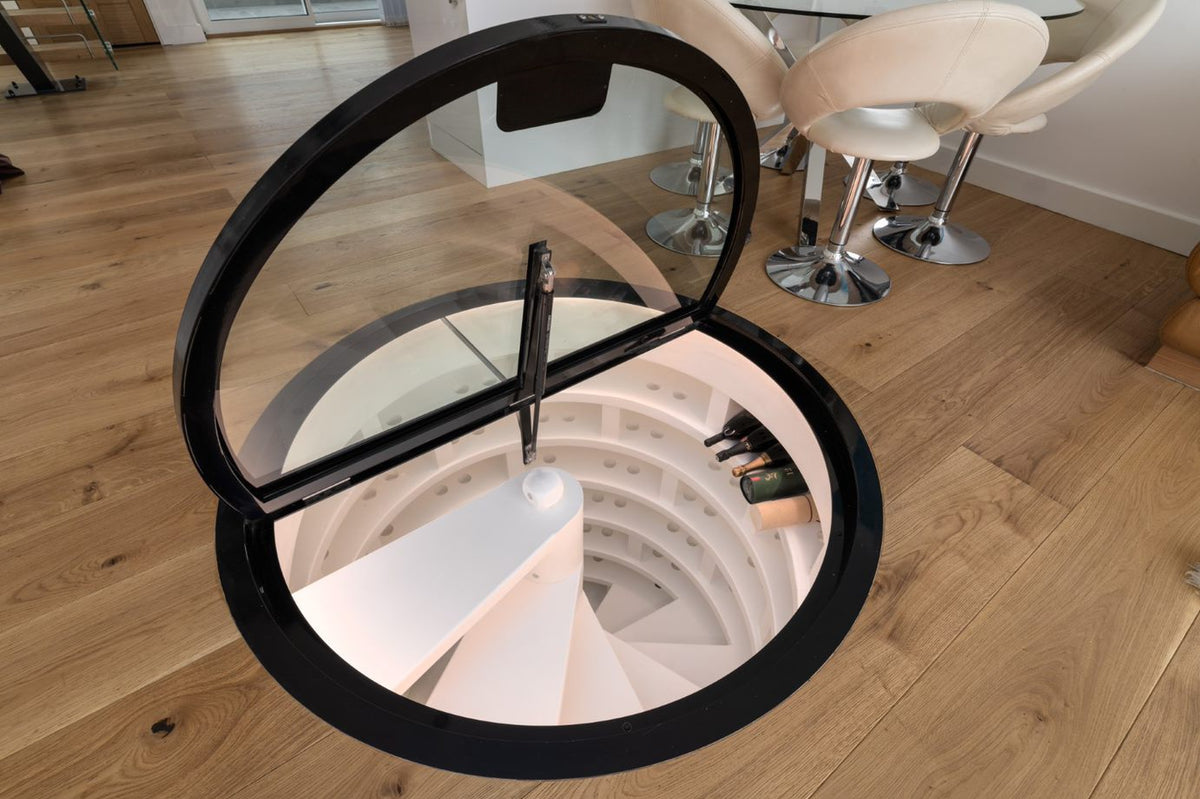 Circular glass hatch over a spiral wine cellar
