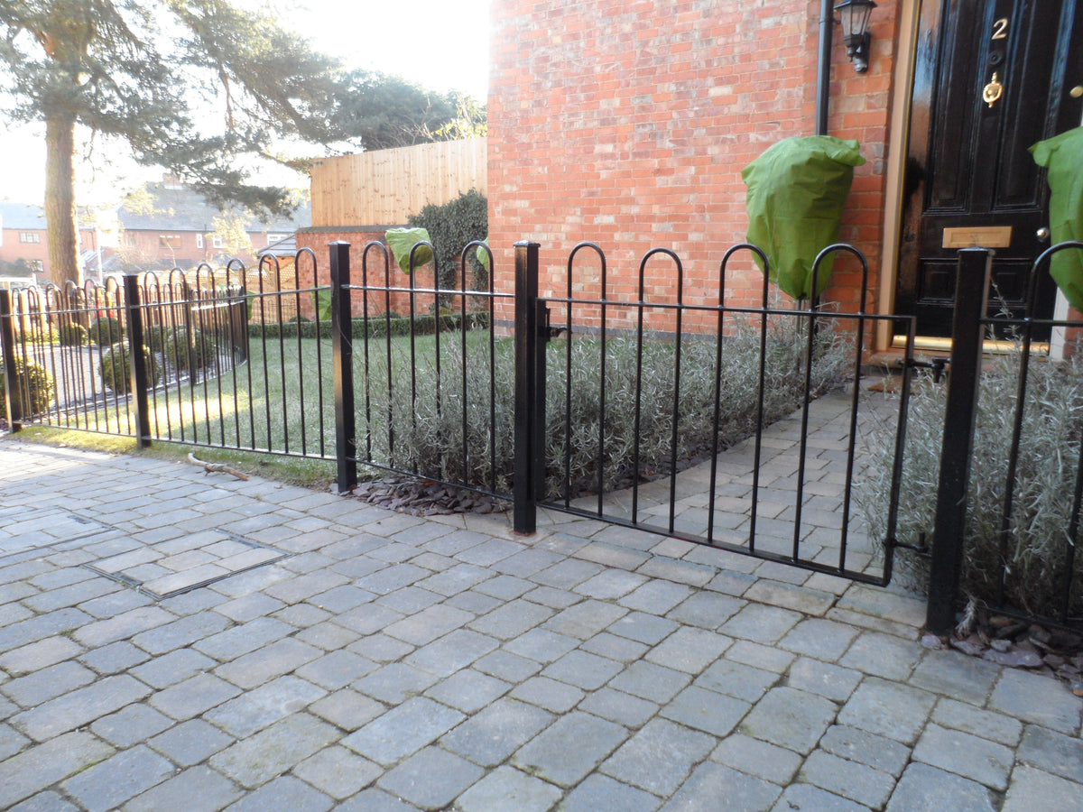 Hoop top metal gate in a matching hoop top railing run, galvanised and powder coated black