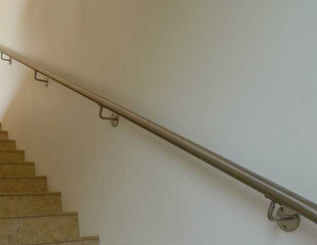 Brushed stainless steel wall rail following the pitch of a stair