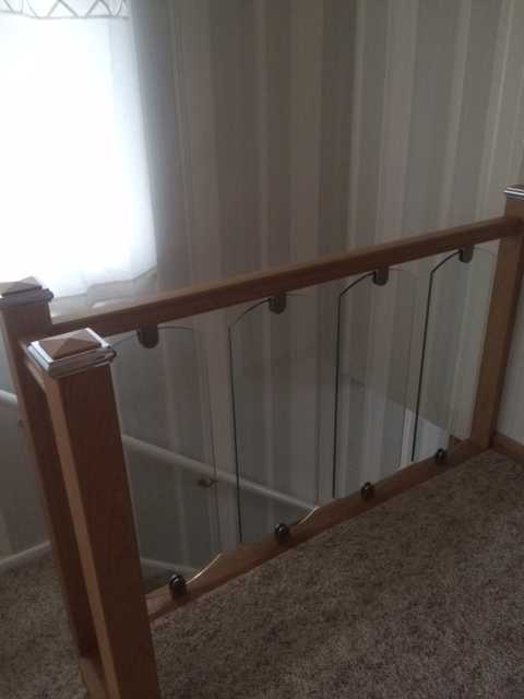 Shaped toughened glass staircase panel in stainless clamps