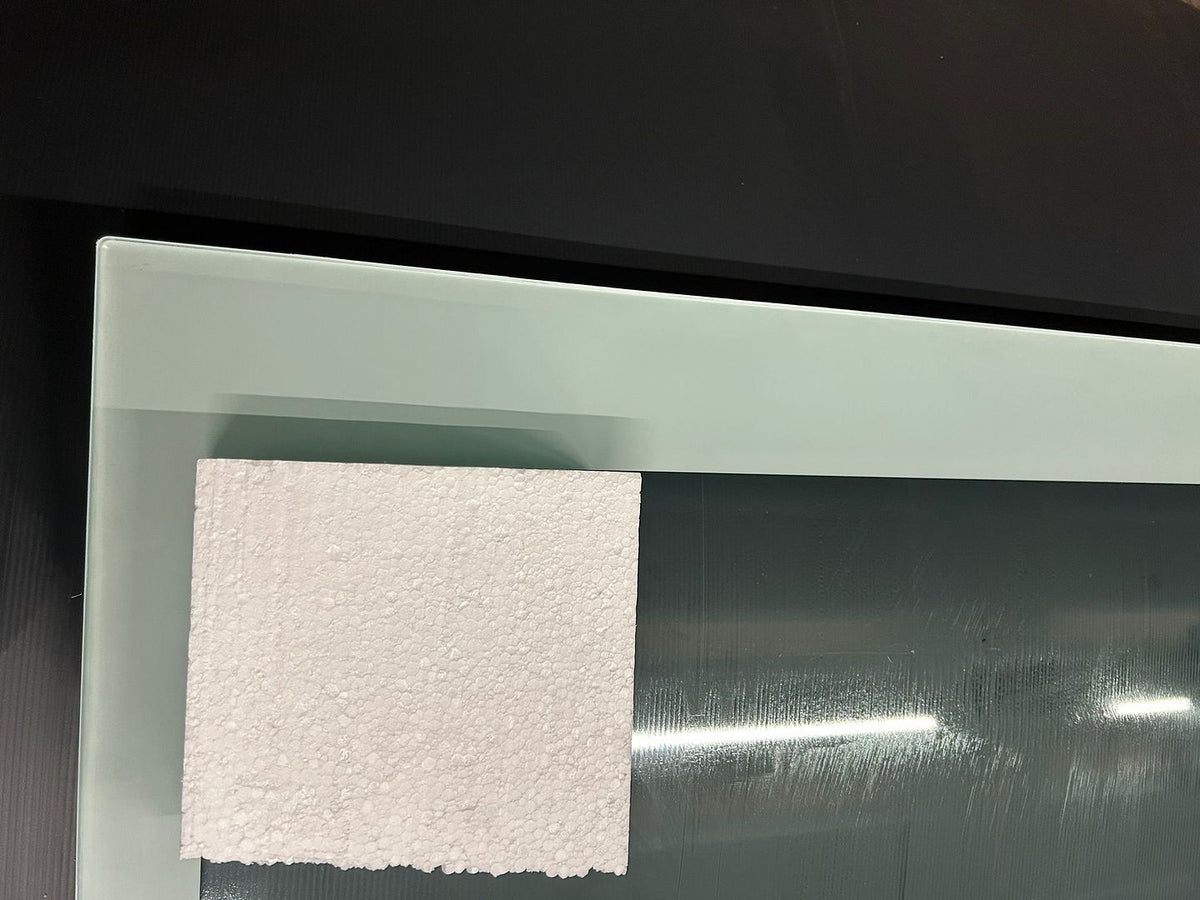 White RAL 9016 painted border on laminated floor glass shown beside white foam, showing the green cast seen through the glass