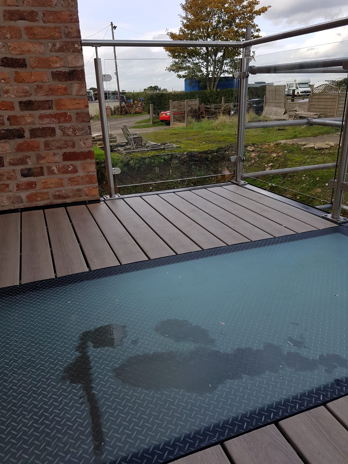 Partial glass floor, a walk-on glass strip set into composite decking on a steel balcony