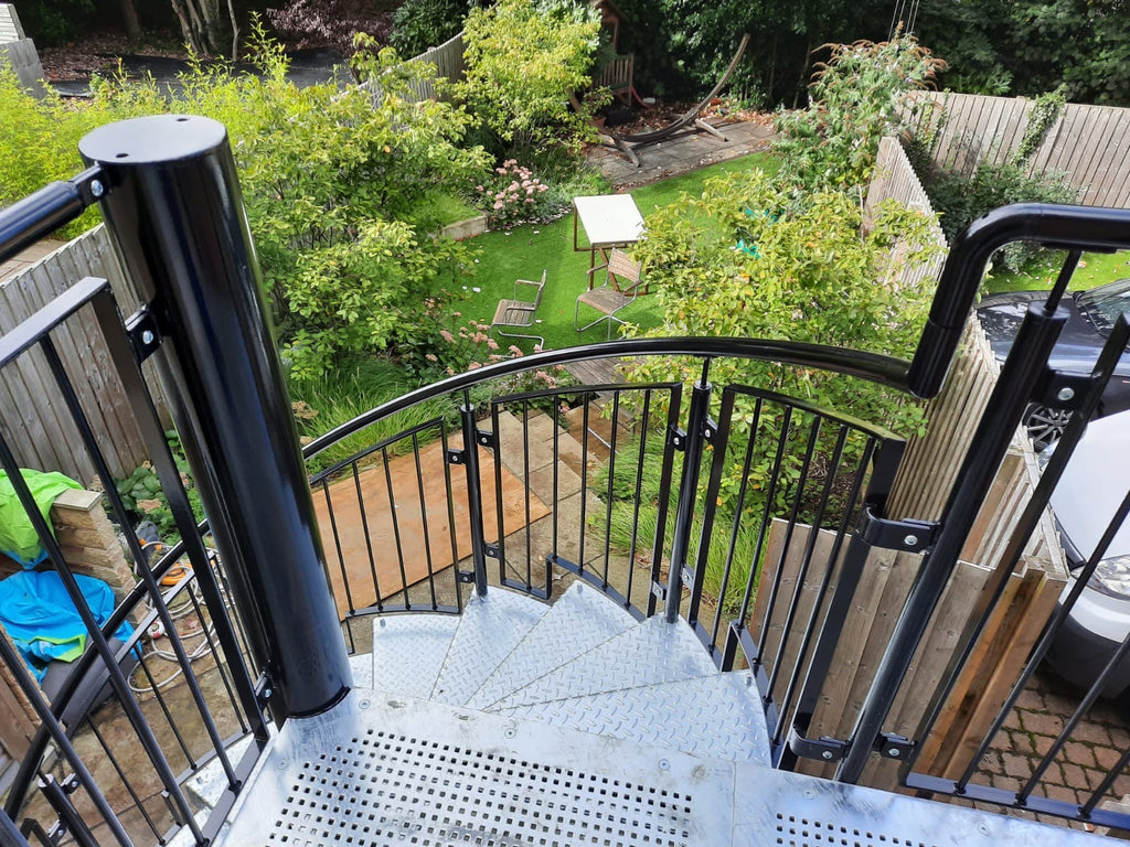 Looking down a bespoke steel spiral staircase onto a garden