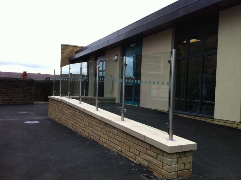 Stainless steel and glass balustrade with base cover discs at floor level