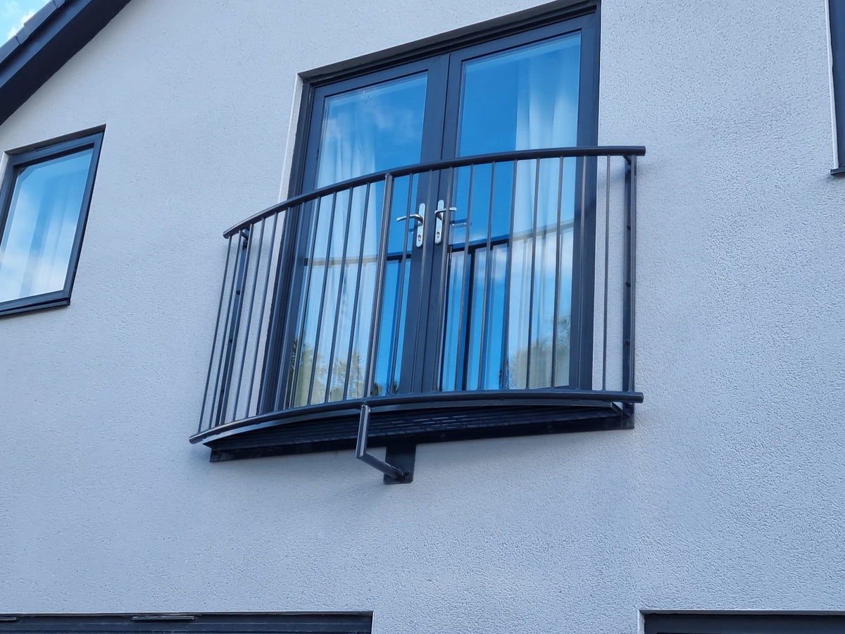 Curved steel Juliet balcony bowing out with a steel mesh platform to stand on