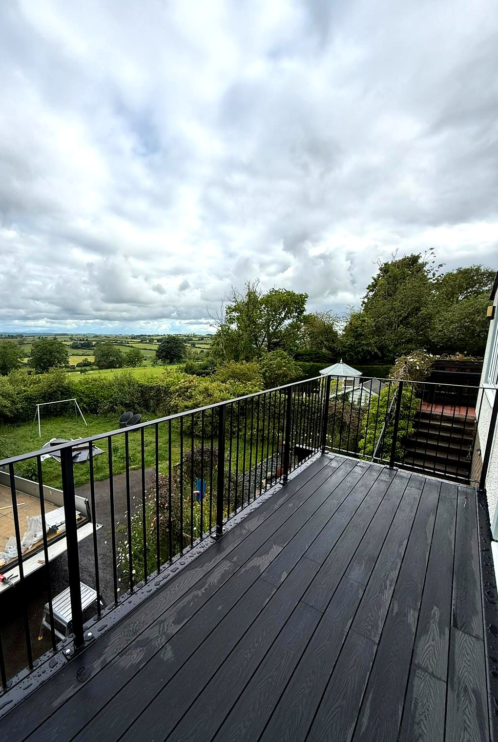 Metal balustrade walk-out balcony with composite decking looking over countryside, Cumbria