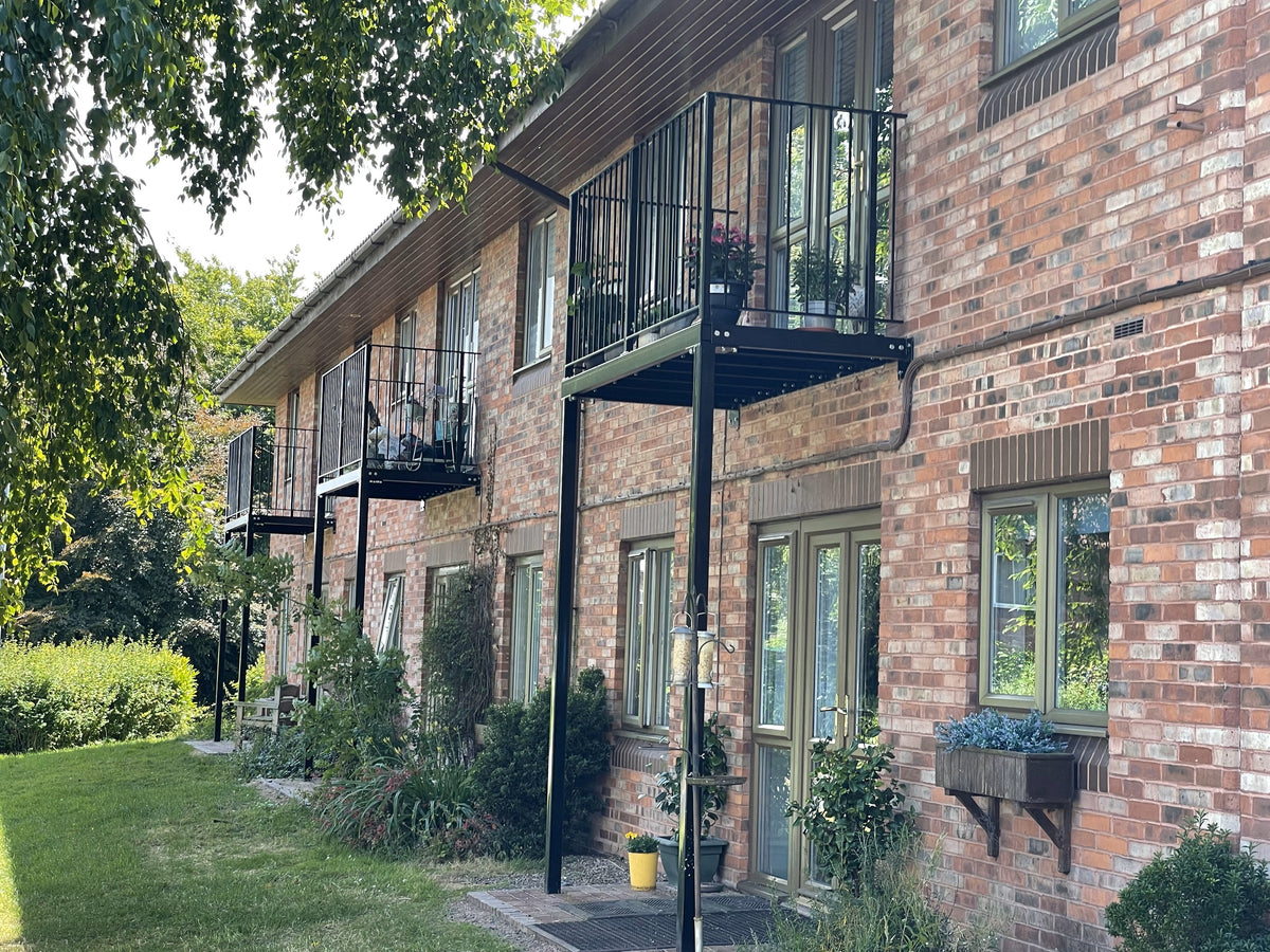 Walk-out metal balcony platform with decked floor and railings