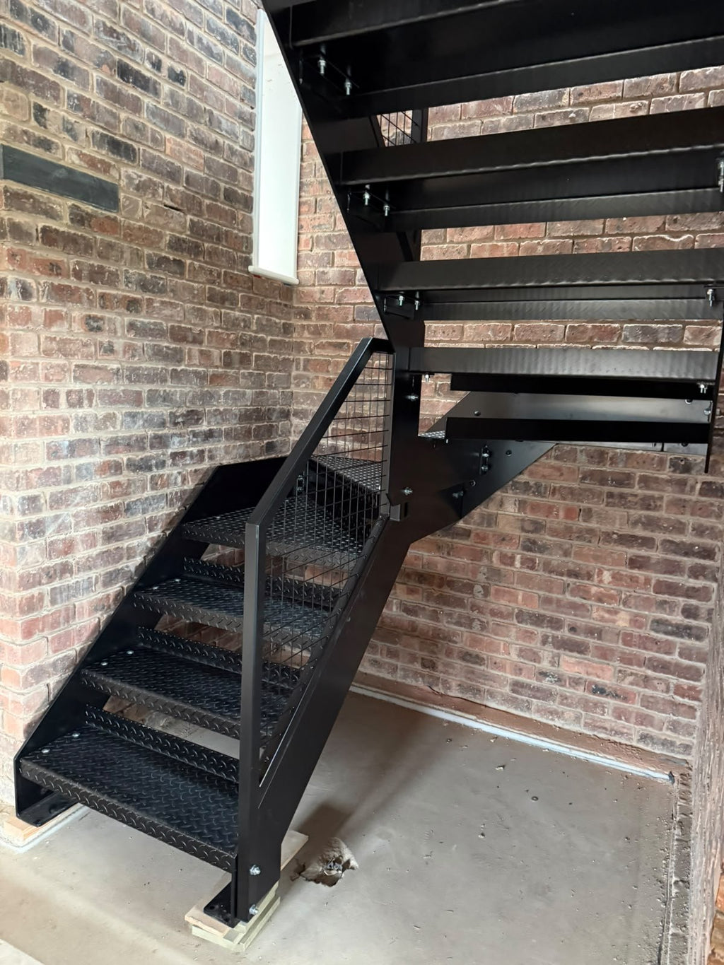 4.5mm Durbar raised pattern chequer plate stair treads on a black steel industrial staircase