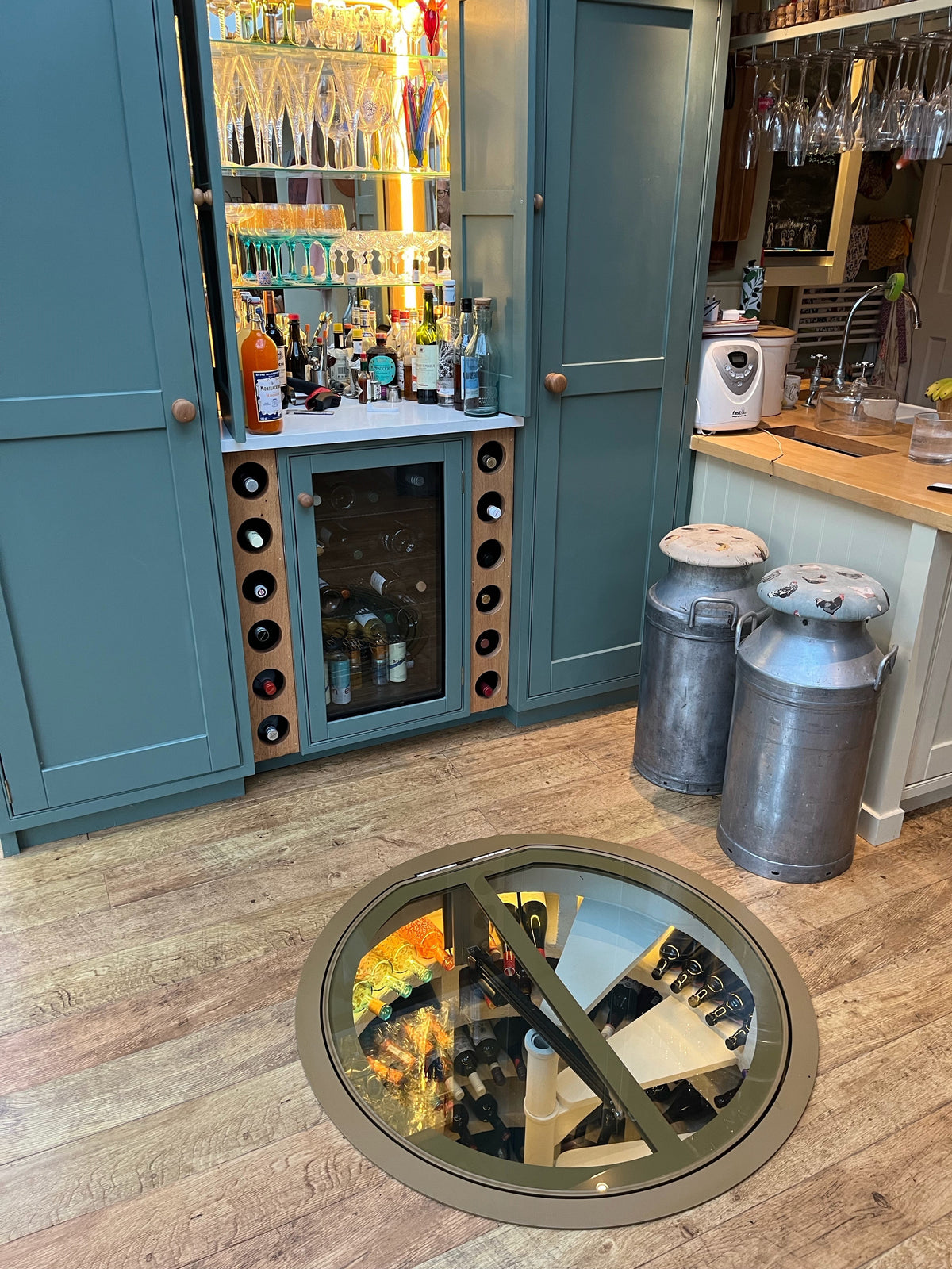 Motorised glass cellar door raised above a spiral staircase
