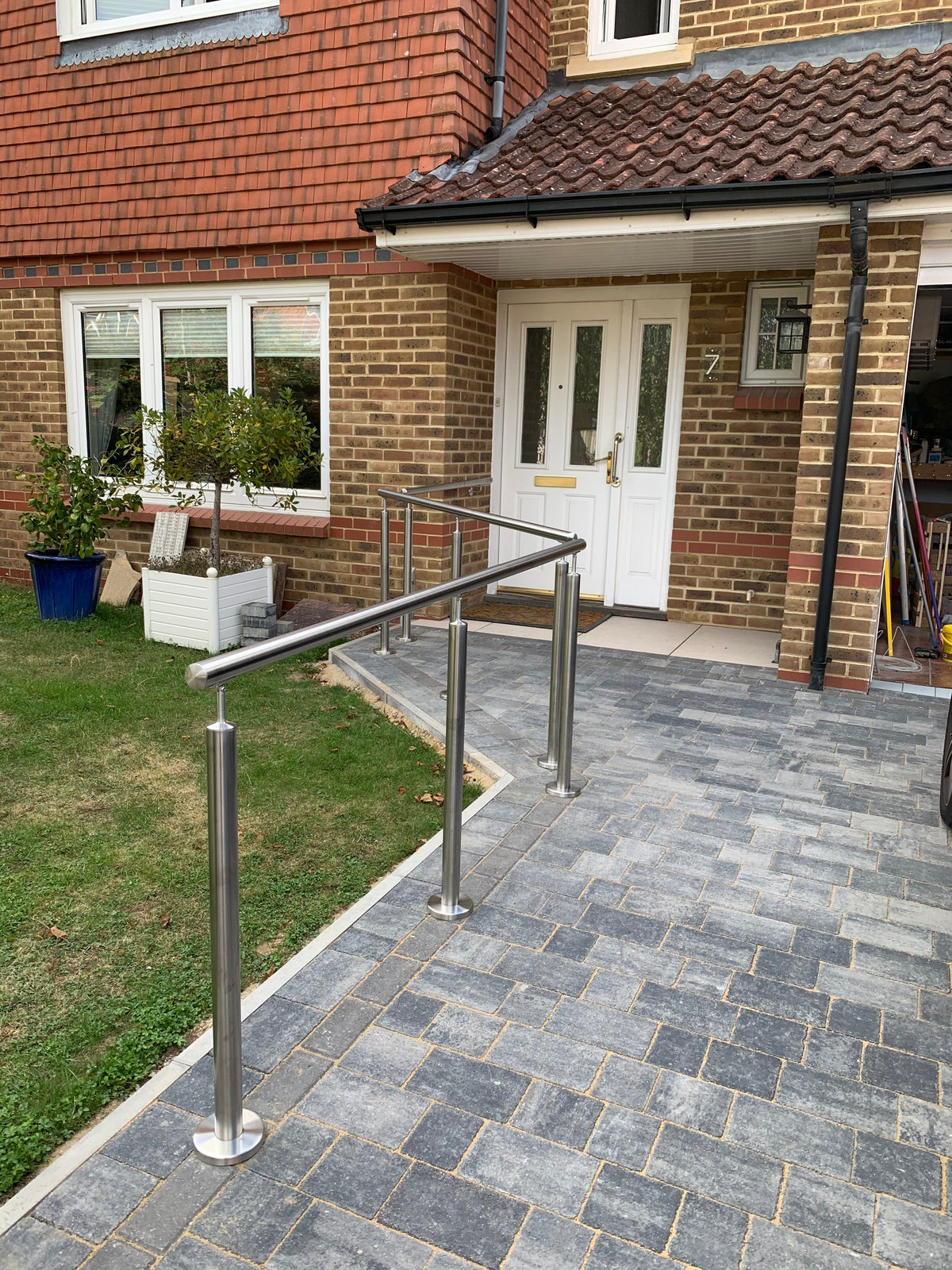 Stainless handrail on posts to entrance steps and a ramp