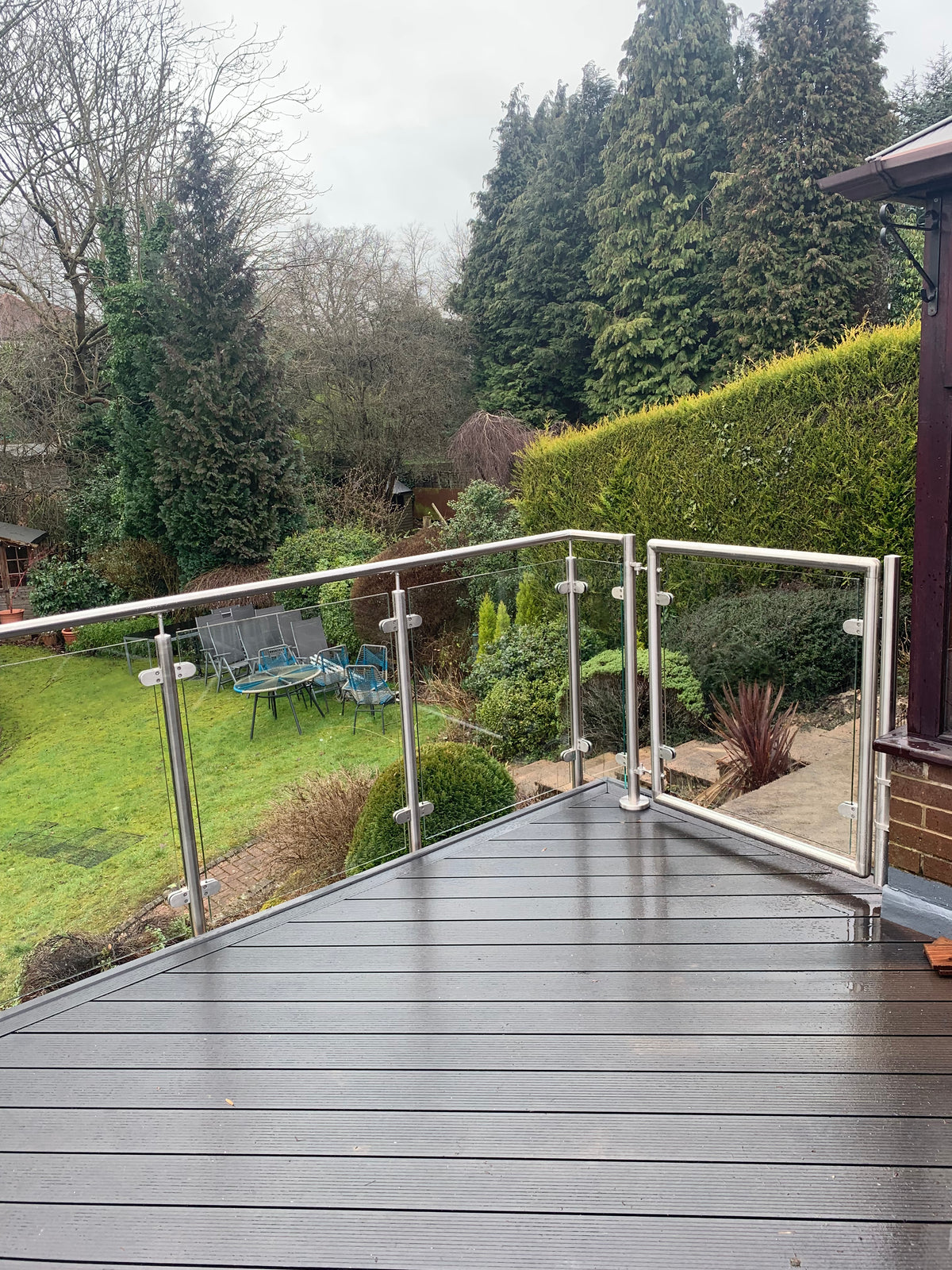 Framed glass gate in a stainless steel and glass balustrade run on composite decking