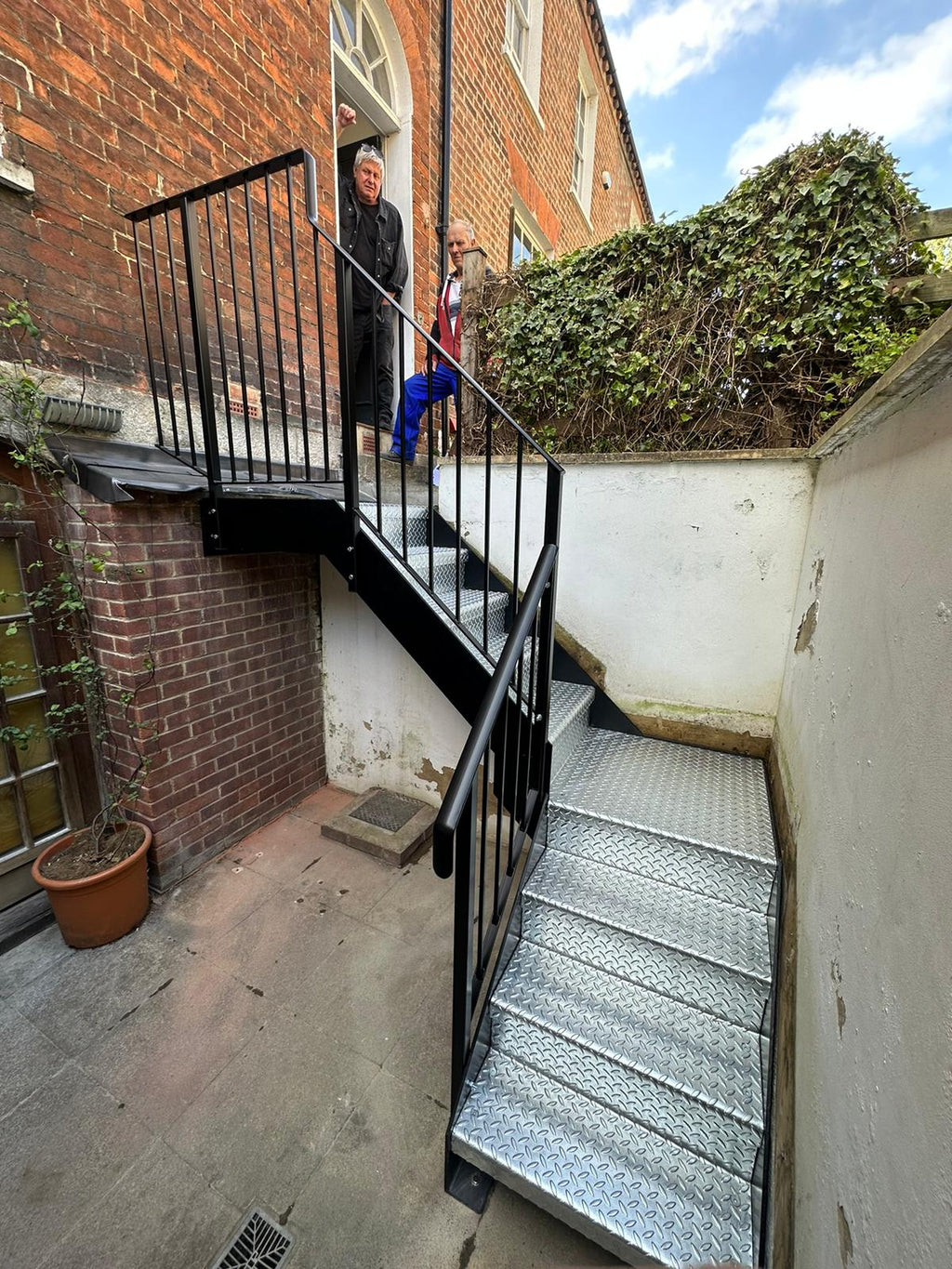 Powder coated external steel staircase with galvanised treads left bare