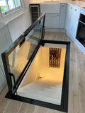 Glass access hatch set into the floor above a cellar