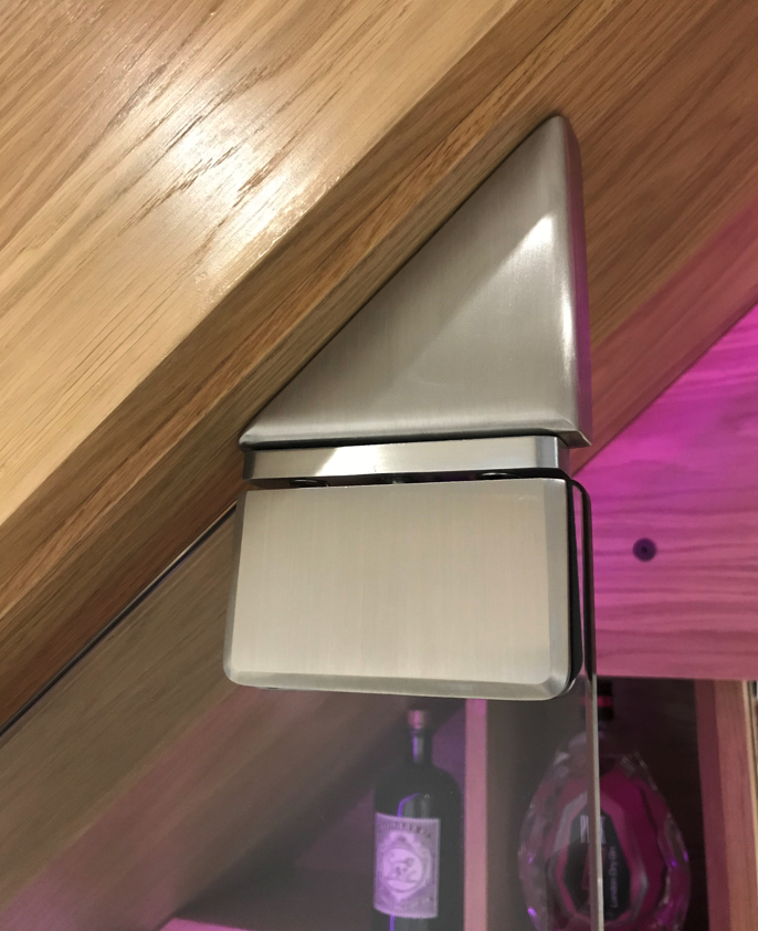 Stainless steel hinge bracket on an under stairs glass door