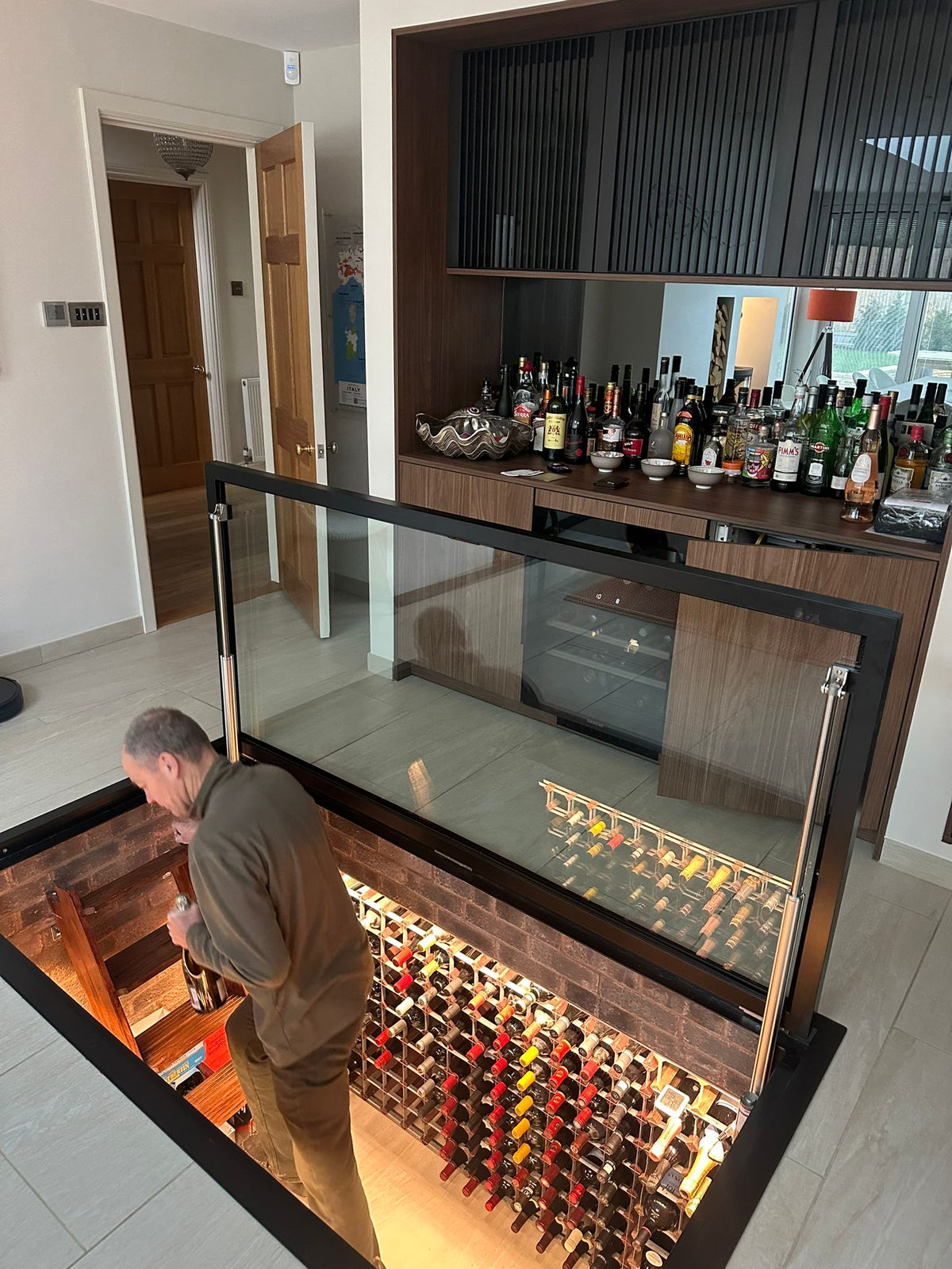 Automatic glass floor door open above a wine cellar below